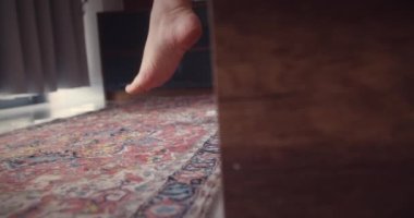 Yakın plan çekim. Yataktan çıkıp pencereye dayanan güzel bir kızın bacakları. Hafif arka plan, sabah uyanır. Beyaz yatak güzel kadın ayak parmakları. Yere yatın. Parke ya da lamine et. fitness bacakları