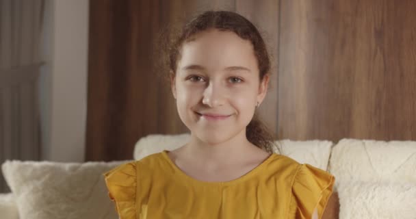 Portret Zabawna Dziewczynka Uśmiechnięte Dziecko Patrząc Aparat Siedzą Kanapie Domu — Wideo stockowe