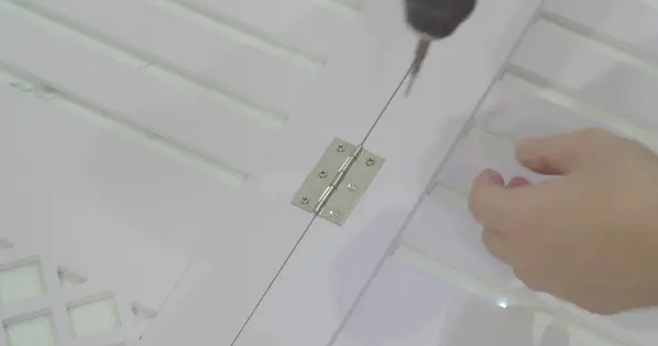 Elektrikli tornavida kullanan bir adam tahtaya vida takıyor. Makro. Yakın plan..