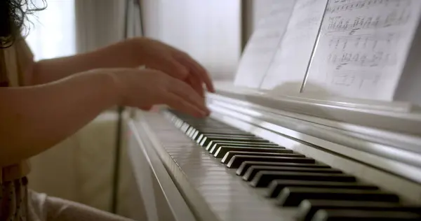 Piyano çalmak. Piyano çalan kadın eller. Piyanoda bileziği olan kadın eller. Kadın tuşlara dokunuyor. Kapatın. 4K.