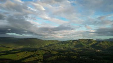 Cennetin güzel, güneşli, bulutlu manzarasında uçmak. Gökyüzünde usulca hareket eden altın tüylü bulutların muhteşem güzelliği ve güzel ışınlar ve parlak ışıklarla bulutların arasında parlayan güneş.