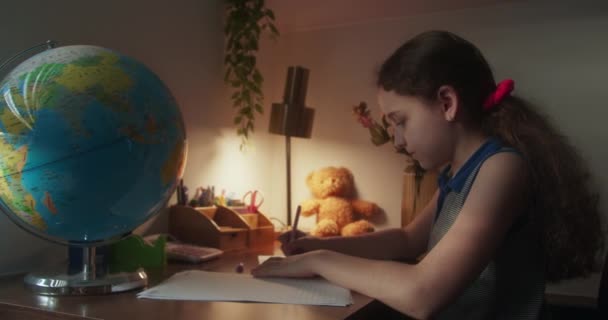 可爱的学龄女孩学习写作 做数学作业 坐在家里桌子旁 可爱可爱的可爱的小女孩一个人在家学习 做数学计算 孩子们的小学教育概念 — 图库视频影像