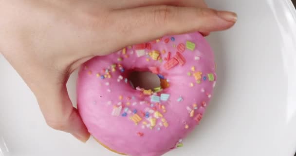 Vrouwenhand Neemt Een Roze Donut Van Een Bord Bakkerij Voedsel — Stockvideo