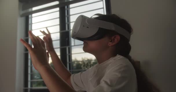 在虚拟现实的镜片中教育孩子 微笑着靠近她的脸 女孩沉浸在网络空间 在虚拟现实中学习 小孩在玩游戏使用虚拟现实耳机学习儿童 — 图库视频影像