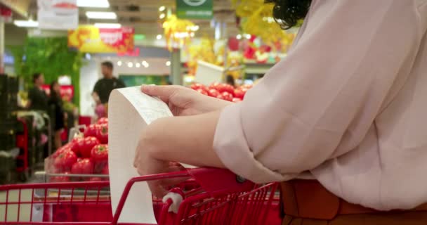 Woman Checks Paper Check Shopping Groceries Mall Red Tomatoes Background — Stock Video