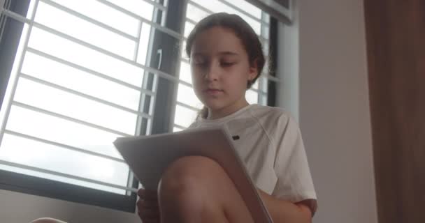 똑똑한 소녀는 노트패드에 씁니다 집에서 귀여운 여학생 그녀의 방에서 침대에 — 비디오
