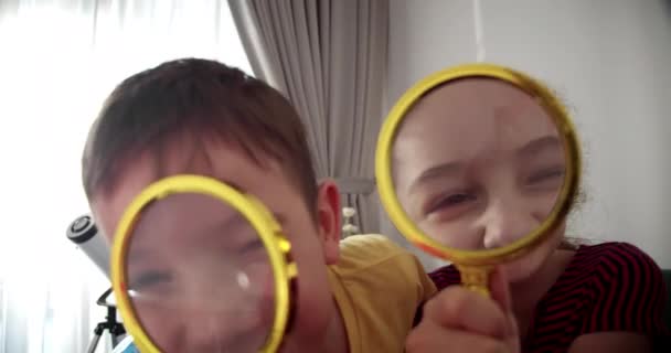 Szczęśliwy Śmieszny Mały Uśmiechnięty Chłopiec Dziewczynka Patrząc Aparat Szkła Powiększenia — Wideo stockowe