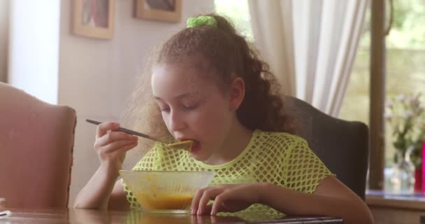 Mooi Klein Meisje Met Zittend Aan Een Eettafel Huiskeuken Pompoensoep — Stockvideo