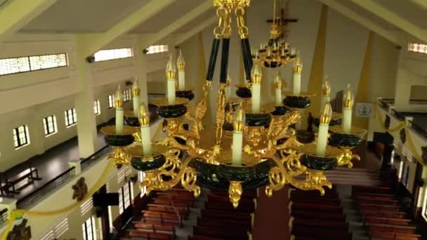 天主教教堂内的头像 俯瞰大吊灯 俯瞰天主教堂教区的长椅 宗教的概念 照相机从左向右运动 — 图库视频影像
