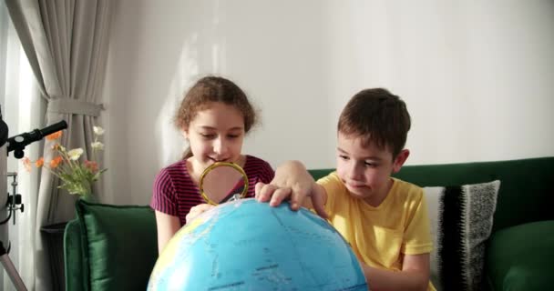 Los Niños Sostienen Lupa Sus Manos Miran Globus Sentados Casa — Vídeo de stock