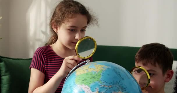 Słodki Chłopiec Dziewczyna Patrząc Globus Przez Szkło Powiększające Technologia Dla — Wideo stockowe