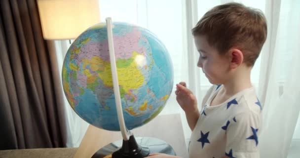 Dziecko Trzyma Szkło Powiększające Rękach Patrzy Kulę Ziemską Siedząc Domu — Wideo stockowe