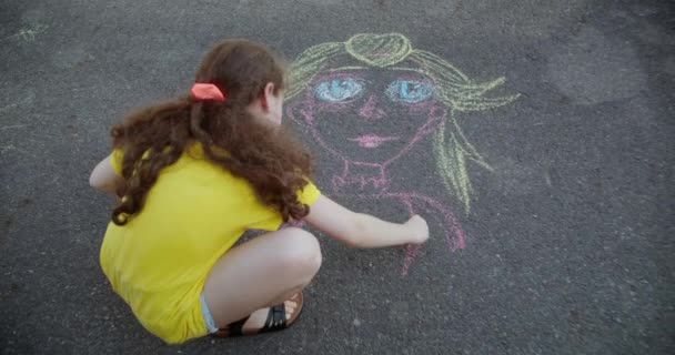 Nettes Kind Zeichnet Ein Mädchen Mit Kreide Auf Den Asphalt — Stockvideo