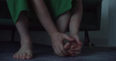 Ayağına masaj yapan adam, bacaklarındaki ağrıyı hafifletmeye çalışır. Adam ayağını yoğurup masaj yapıyor, yakın plan. Eklem iltihabı olan olgun bir adam yatakta oturuyor, ayak bileğini ve ayağını ovuyor.