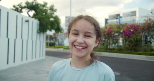 거리에 긍정적인 초상화 카메라를 소녀는 선명한 행복으로 카메라를보고 매력적인 초상화를 — 비디오