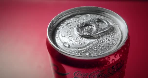 冷冰冰的可口可乐在红色的背景下饮用 2024红色金属罐中的一个可可豆旋转 瓶子上的水滴 很好的电影镜头概念生产或可制造 — 图库视频影像