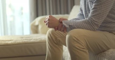 Kapatın. Erkek eller, evdeki oturma odasında kanepede otururken diz kaslarına masaj yapıyor. Yaşlı siyahi adam diz eklem ağrısı çekiyor, yürüyemiyor, hastalık, kramp, romatizma.
