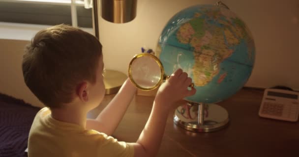 Skolbarn Morgonljuset Sitter Vid Ett Bord Hemma Och Tittar Världen — Stockvideo