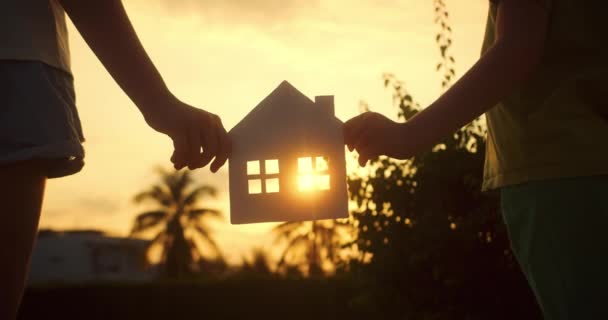 Mãos Família Estão Segurando Uma Casa Papel Pôr Sol Sol — Vídeo de Stock