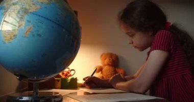 Ödev yapan çocuk, okuyan çocuk. Ergen kız evde ders çalışıyor. Genç bir öğrenci evde öğreniyor, notlar alıyor, ödev yapıyor. 4K.