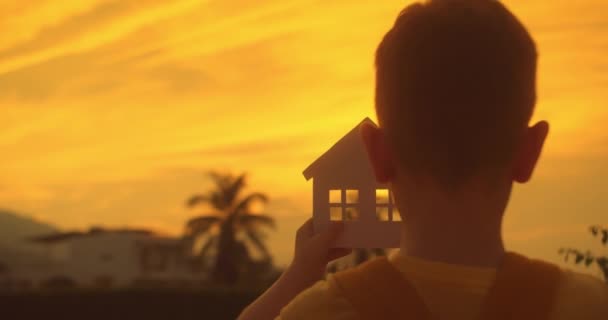纸制房屋的手家庭 阳光在窗户近处闪耀 日落时的造纸厂象征着家 家庭的安慰 概念建筑房子的家庭 梦想买房子 房地产保险 — 图库视频影像