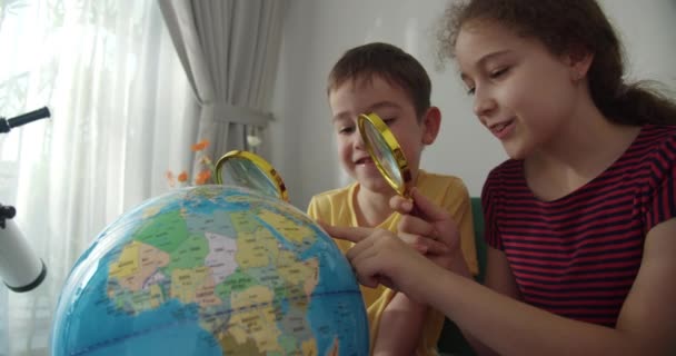 Children Holds Magnifying Glass His Hands Looks Globus Sitting Home — Stock Video