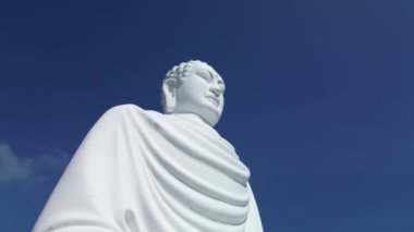Uçsuz bucaksız mavi gökyüzü ve Vietnam 'ın Büyük Buda' sı. Uçsuz bucaksız mavi gökyüzünde büyük Buda beyaz heykeli. Beyaz Buda Vietnam, Nha Trang Vietnam 'ın simgelerinden biridir. 4K.