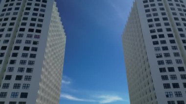 Yüksek binaların insansız hava aracı görüntüleri Vietnam 'ın gökdelenleri binalara yaklaşıyor. Khanh Hoa, Nha Trang, Vietnam. Güneşli zaman, arkadaki mavi siluet. 4k