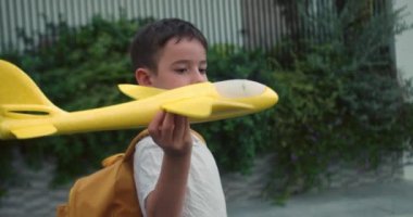 Çocuk pilot ve astronot olmak istiyor. Ağır çekim. Mutlu çocuk, gün batımında parkta oyuncak bir uçakla koşuyor. Çocuklar oyuncak uçak oynarlar. Gençler uçmayı ve pilot olmayı hayal eder. 4K