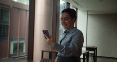 Ofiste akıllı telefon kullanan, güzel yüzlü, kendine güveni tam, güzel bir Hintli genç bayan. Gülümseyen güzel bir kadın cep telefonu kullanıyor. Mutlu iş kadını 30 yaşında Hintli kadın konuşuyor.