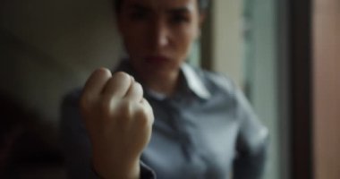 Çekici iş kadını, 30 yaşında, ciddi bir genç kadın kameraya yumruk hareketi yapıyor, aile içi şiddete, kürtaja, ırka ya da cinsiyete karşı kadınlar.