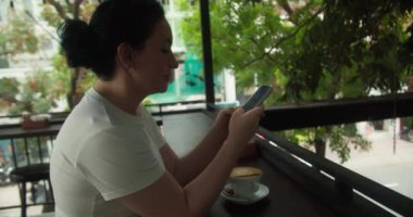 Rahat genç bir kadın akıllı telefon kullanarak sosyal medyada sörf yapıyor, haberleri kontrol ediyor, mobil oyunlar oynuyor ya da koltukta oturmuş mesaj yazıyor. Milenyum bayanı evinde cep telefonu teknolojisiyle vakit geçiriyor.
