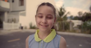 Küçük Çocuk Kız 'ın Yaz Günü' nde Cadde 'de duran kameraya baktığı portre. Genç Mutlu Düşünen Meraklı Çocuk Dışarıda Kameraya Yakından Bakıyor. Yüz Gözleri Komik Düşünceli Çocuk. 4K