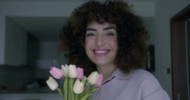 Geniş açılı, öfkeli, çiçek buketi kıran ve çaresiz yüz ifadesiyle kameraya bakan genç bir kadın. Ayrıldıktan sonra poz veren umutsuz beyaz kadın portresi.