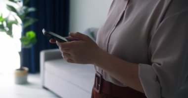 Cep telefonu kullanan ya da sohbet eden bir kadın eli. Kadın ellerini kapalı kapılar ardında tut. 4K