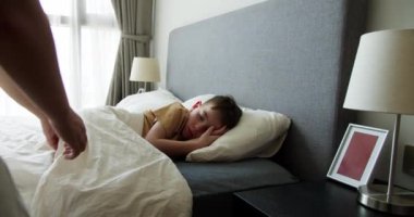 Anne oğluna bakıyor. Yatakta uyuyan bebek. Yan yatmış uyuyan çocukla yüzleş. İzleme, gece yarısı uyuyan bebeği vurdu. Küçük erkek bebek beşiğinde tatlı tatlı uyuyor ve uykusunda gülümsüyor.