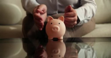 Büyükannesinin elinde torunları için bozuk paralarla mavi domuz kumbarası var. Ailedeki yaşlılara sevgi ve ilgi. Yağmurlu günler için çocuk birikimleri. 4K