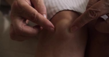 Emeklilerin ellerinin popliteal ya da sinoviyal kisti ovalarken, dizlerinin arkasında sıvı dolu bir şişlik oluşur. Popliteal kist, eklem sıvısı. Yaşlı bir kadının diz eklemi zarar görmüş.