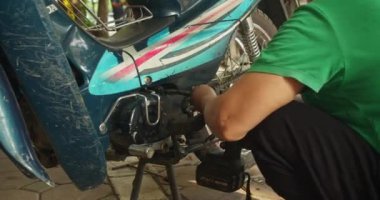 Yetenekli bir kadın tamirci bir atölyede bir motosikleti tamir eder. Hanoi, Vietnam 'da, kendi dükkanında motosikletler üzerinde çalışıyor, üst düzey bir oto tamircisi olarak uzmanlığını gösteriyor.