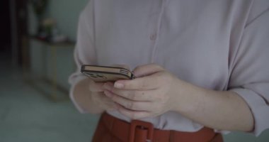Cep telefonu kullanan ya da sohbet eden bir kadın eli. Kadın ellerini kapalı kapılar ardında tut. 4K