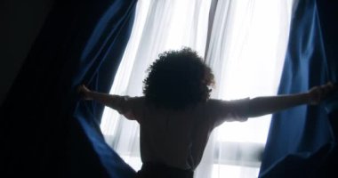 Odasındaki perdeleri açan kıvırcık saçlı kadın. 4K içinde video