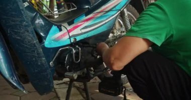 Yetenekli bir kadın tamirci bir atölyede bir motosikleti tamir eder. Hanoi, Vietnam 'da, kendi dükkanında motosikletler üzerinde çalışıyor, üst düzey bir oto tamircisi olarak uzmanlığını gösteriyor.