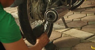 Yetenekli bir kadın tamirci bir atölyede bir motosikleti tamir eder. Hanoi, Vietnam 'da, kendi dükkanında motosikletler üzerinde çalışıyor, üst düzey bir oto tamircisi olarak uzmanlığını gösteriyor.