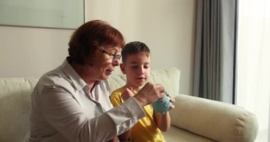 Sevecen, mutlu, yaşlı bir kadın büyükanne ve sevimli küçük bir kız torun kalp şeklinde el hareketi yapıyorlar. Kamera kaynaşmasına bak gülüşüne aile sevgisi kavramını gösteriyor, yakın plan portre