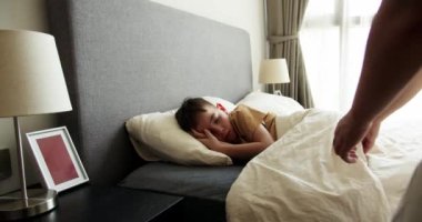 Anne oğluna bakıyor. Yatakta uyuyan bebek. Yan yatmış uyuyan çocukla yüzleş. İzleme, gece yarısı uyuyan bebeği vurdu. Küçük erkek bebek beşiğinde tatlı tatlı uyuyor ve uykusunda gülümsüyor.