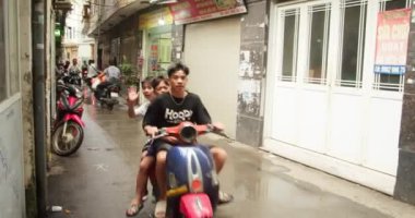 Hanoi, Vietnam - 7 Aralık 2024. İnsanlar yağmurlu havada, Hanoi, Vietnam 'ın dar bir bölgesinde motosiklete biniyorlar. Hanoi Vietnam, Hanoi Trafiği, Şehir Çevresi