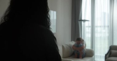 Aile içi şiddet. Bir anne, kanepede oturan çocuğuna doğru elini kaldırır, yüzünü kapatır ve korkuyla gözlerini kapatır. Anne öfkeyle genç kızına bağırır. 4K içinde video