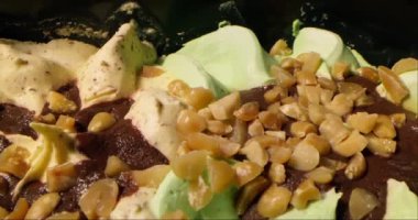 Vanilyalı dondurma ve fıstık serpiştirilmiş şam fıstığının kaygan görüntüsü. Çikolata parçalı, fındıklı ve vişneli dondurma. Yiyecek konsepti