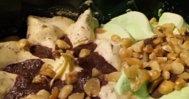 Vanilyalı dondurma ve fıstık serpiştirilmiş şam fıstığının kaygan görüntüsü. Çikolata parçalı, fındıklı ve vişneli dondurma. Yiyecek konsepti