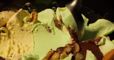 Vanilyalı dondurma ve fıstık serpiştirilmiş şam fıstığının kaygan görüntüsü. Çikolata parçalı, fındıklı ve vişneli dondurma. Yiyecek konsepti